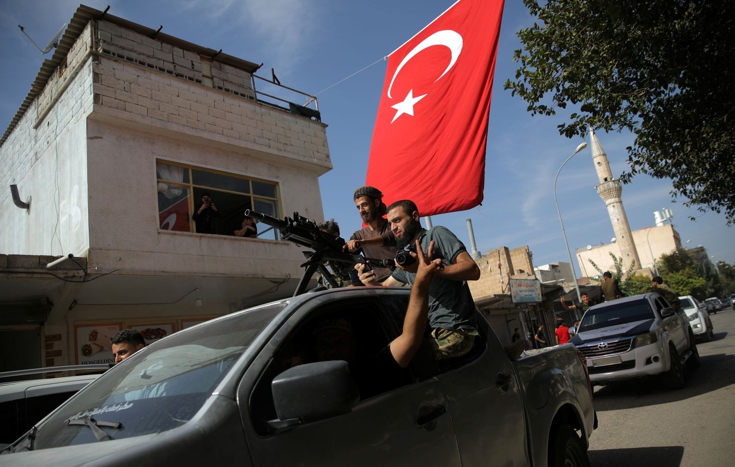 Turkish-backed Syrian rebels drive on a street in the Turkish border town of Akcakale in Sanliurfa province on Oct. 14, 2019. (Stoyan Nenov/Reuters)
