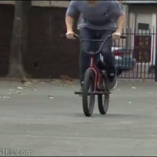 A guy rides along a curved railing on his BMX bike