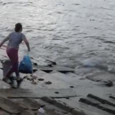 바다에 쓰레기를 버리는 여인