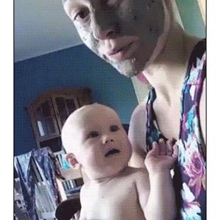 A baby is scared by a mud mask.