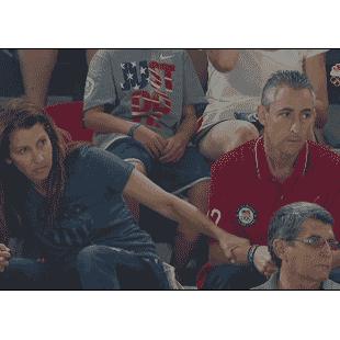 Nervous parents watch their daughter perform at the Olympics.
