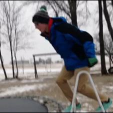A guy jumps onto a trampoline covered in ice