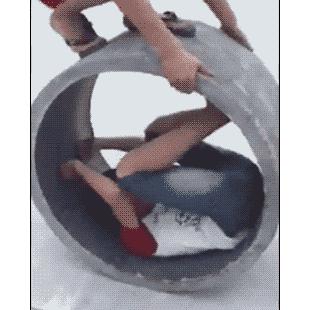 A kid attempts to roll inside a concrete pipe.